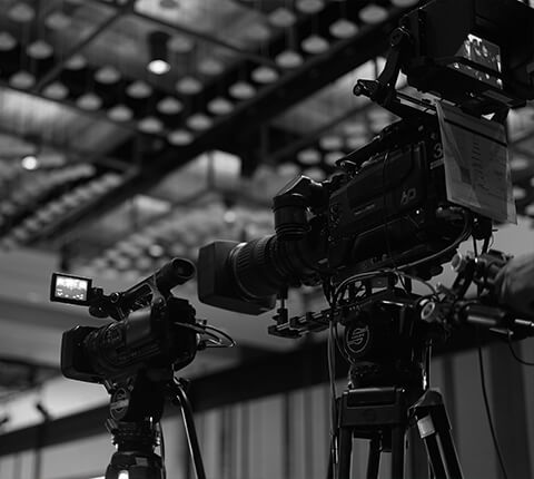 A black and white photo of a camera and a tripod